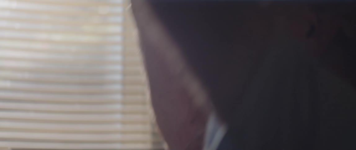 A silhouette of a person with a cap in his hand and placing it on his head