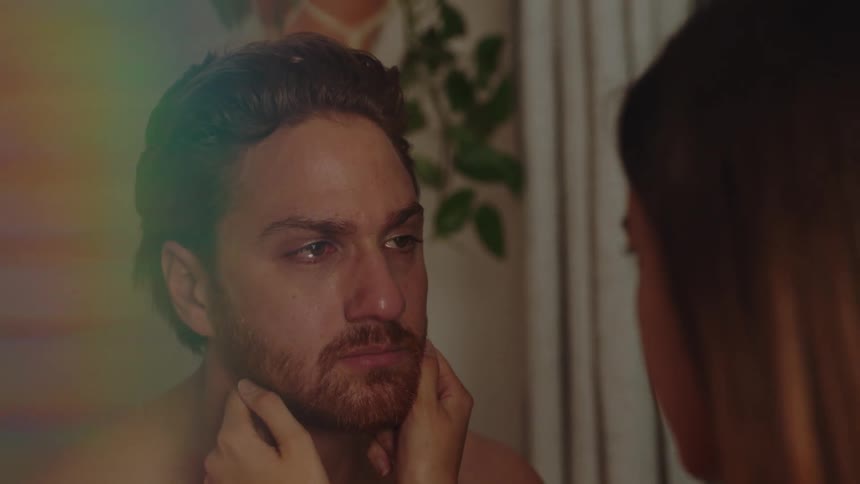 Woman consoles a sad crying man in the bedroom