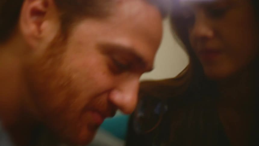 Young couple sitting on the couch about to kiss