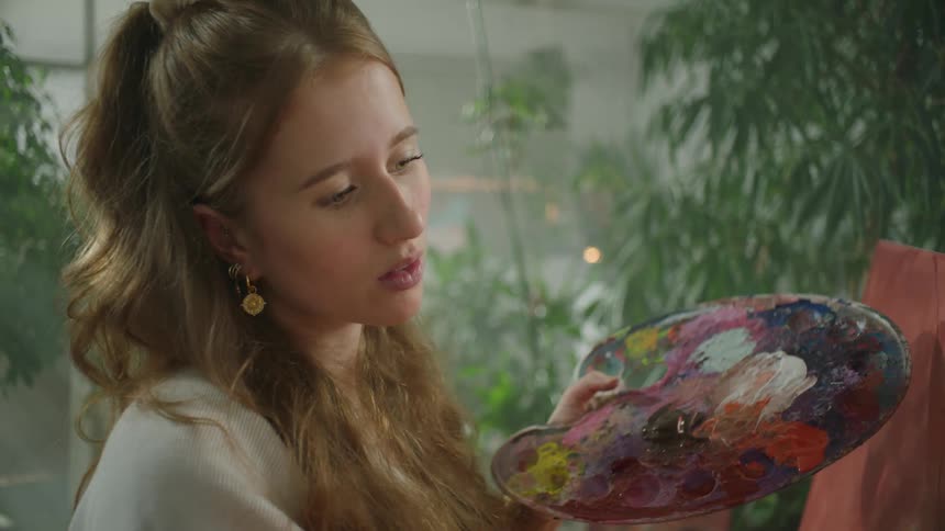 A woman is painting on the canvas