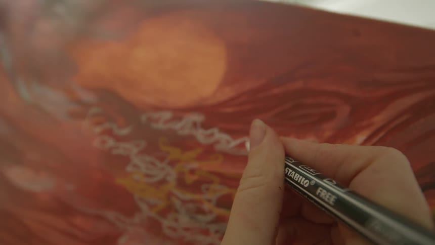 A person takes a pen and paints a picture