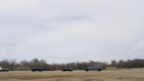 Police vehicles drive down the road