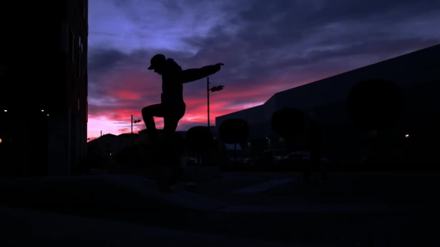 Silhouette of a man riding a skateboard at sunset