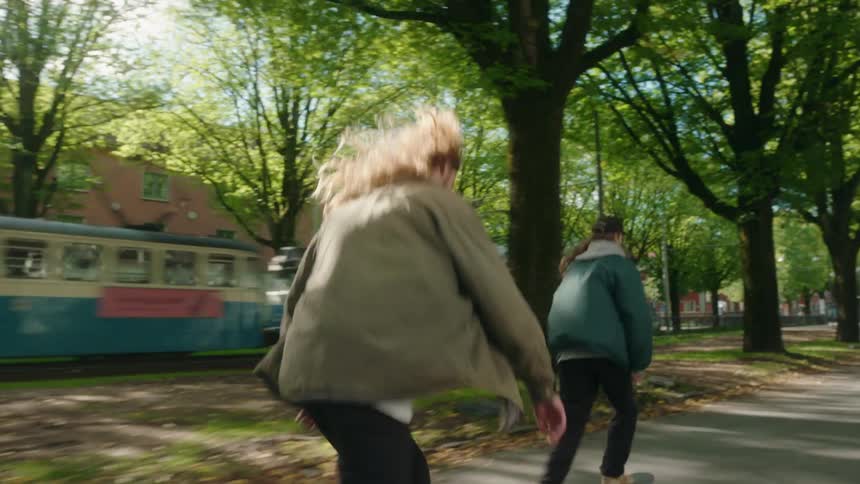 Skateboarders ride skateboards on the street with tram running on trails in the neighborhood