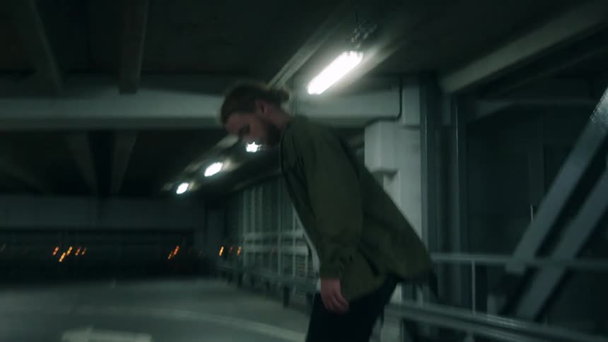 There is a white man that is riding his skateboard at night time