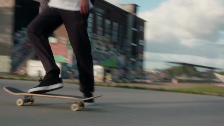 Skateboarder rides skateboard near bridge and river