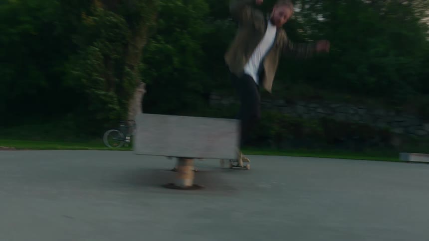 A man is doing skateboard tricks on open pavement in a city