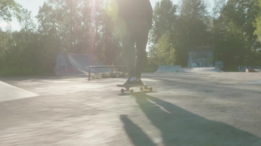 A teenage girl is riding a skateboard and she goes over a ramp and leaps into the air