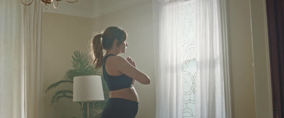 A pregnant woman practices gentle yoga and stretching during a calm morning moment at home