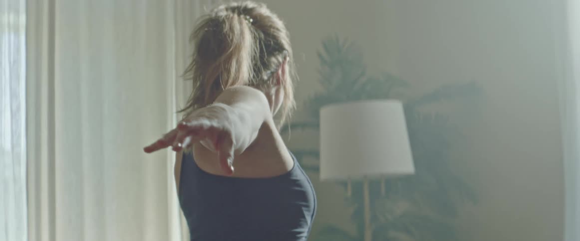 Pregnant woman with sport bra and tights works out in the living room at home