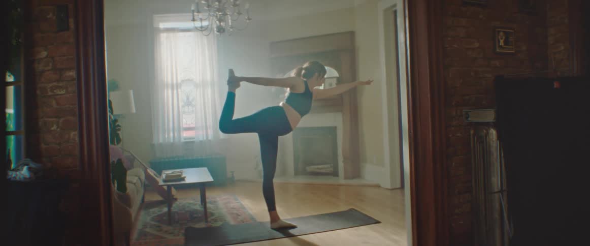 Pregnant woman with a ponytail warms up before working out in the living room at home
