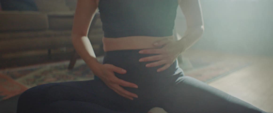 A woman is doing yoga in her living room