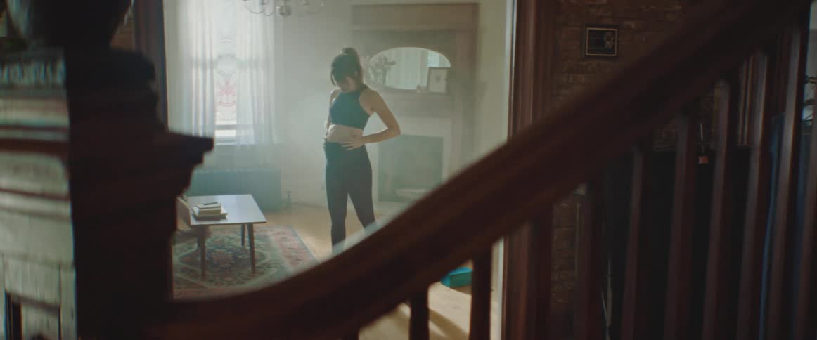Pregnant woman does stretching exercise on a pilates mat in the living room at home