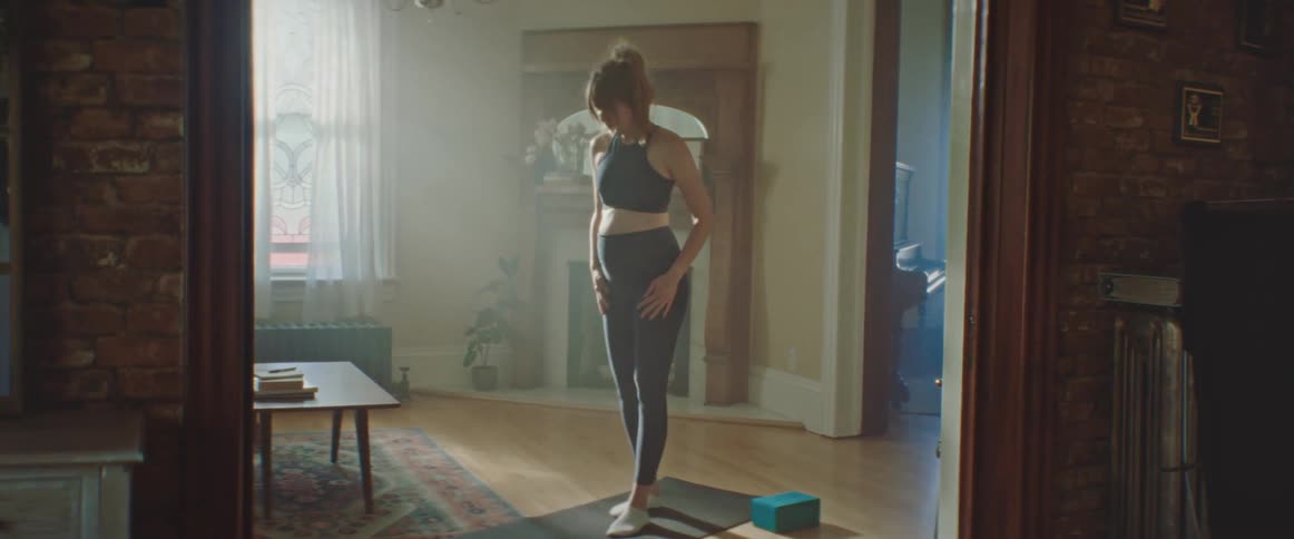 Pregnant woman unrolls a pilates mat to work out