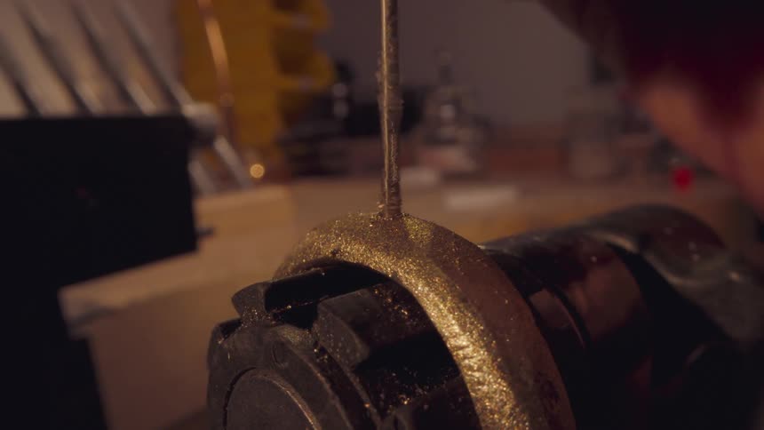 A drill drilling into a shiny material