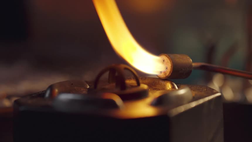 Blowtorch touching an object and emitting flames