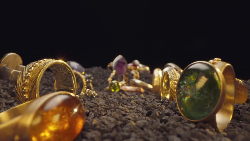 Various golden rings with jewelry stones on a wood chip surface