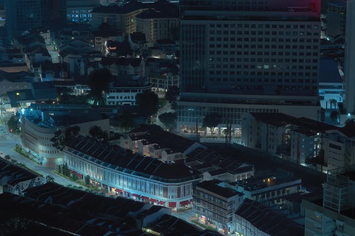 Skyline of apartments with traffic in an urban city at night as lights turn off