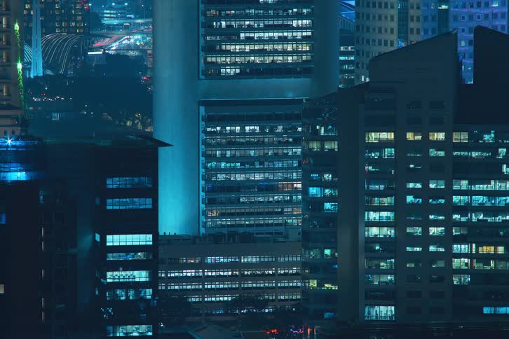 The city lights turn on, then flash rapidly in the buildings