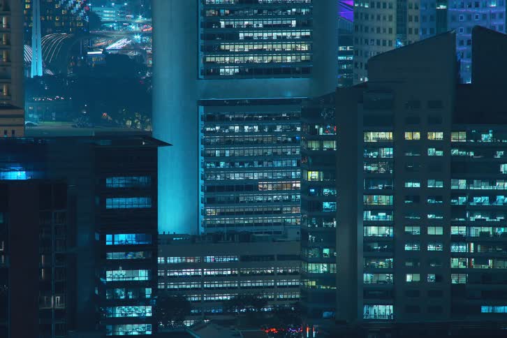 City with high rise buildings lights turn on at sped up time