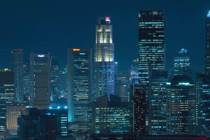 Lights turn on rapidly in buildings all around the city