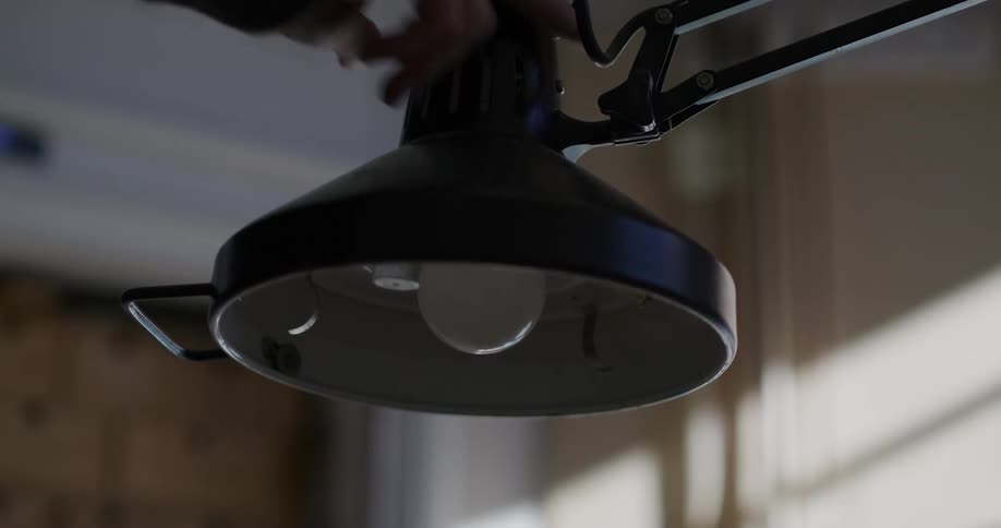 Person positioning a table lamp and turning it off
