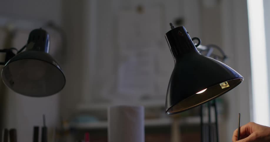 A woman is painting under the lamp