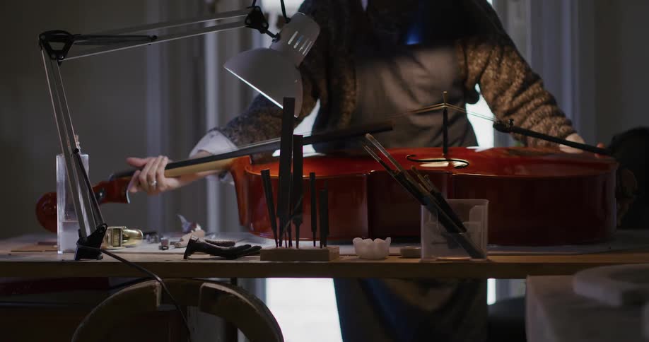 A person places a cello on a table with cleaning tools