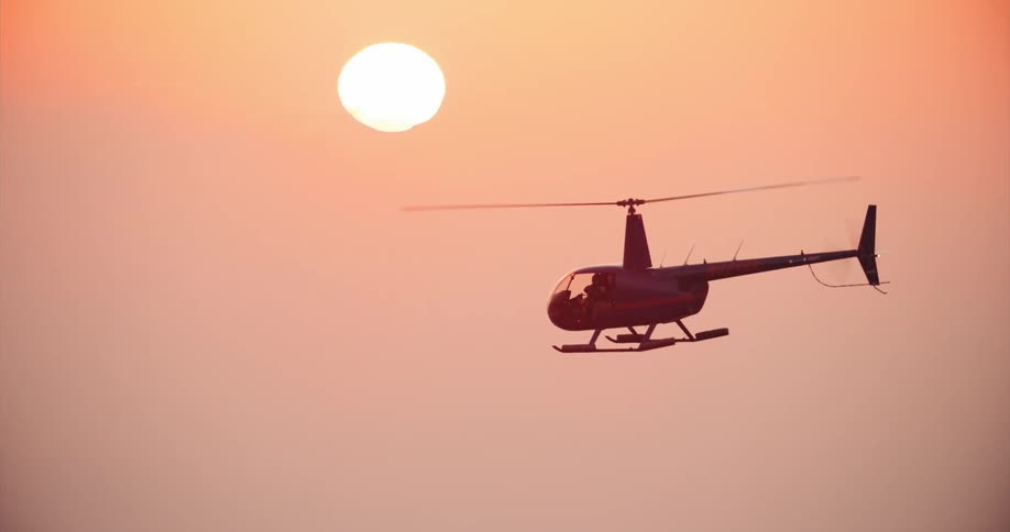 A helicopter flying over San Francisco at sunset