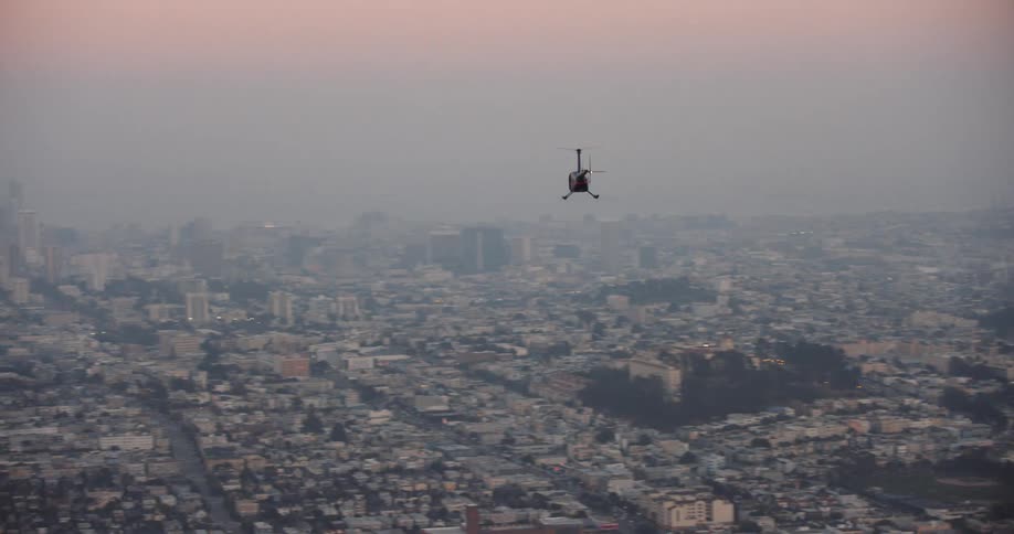 San Francisco, An aerial view of a helicopter flying over a metropolis in the evening