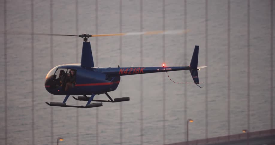 Helicopter flying alongside the Golden Gate Bridge over the San Francisco Bay