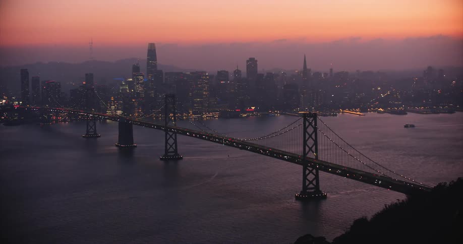 Traffic crossing the San Francisco Bay Bridge at sunset
