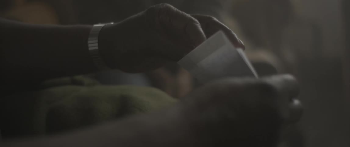 A woman gives an envelope of photographs to a man