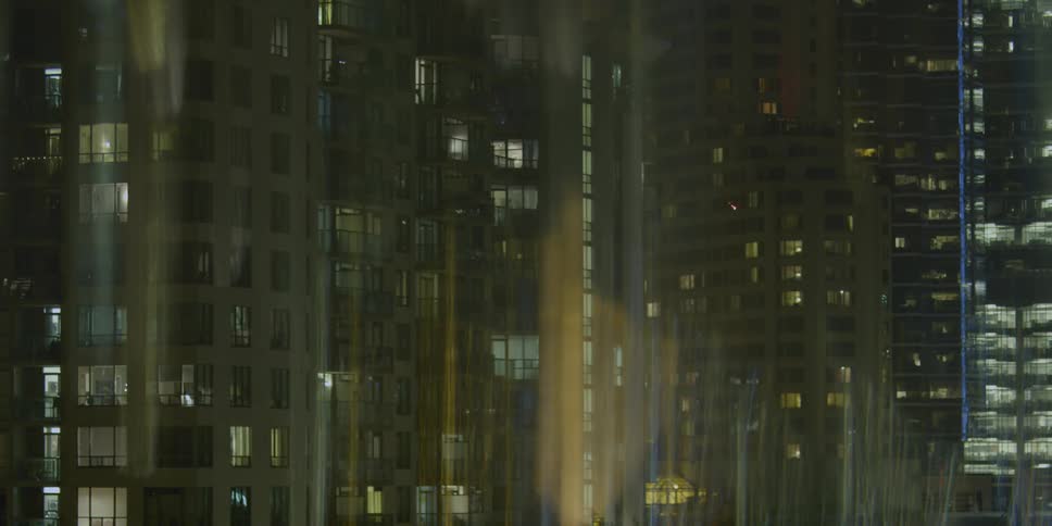 A row of buildings are lit up partially at night