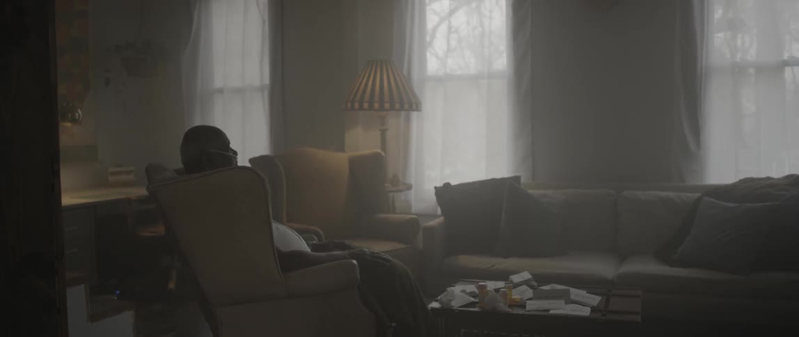 A man is sitting in a chair in the living room