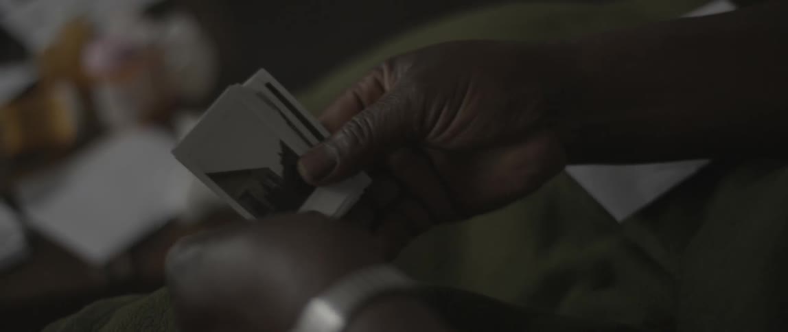 A person pulls pictures from an envelope and looks through them