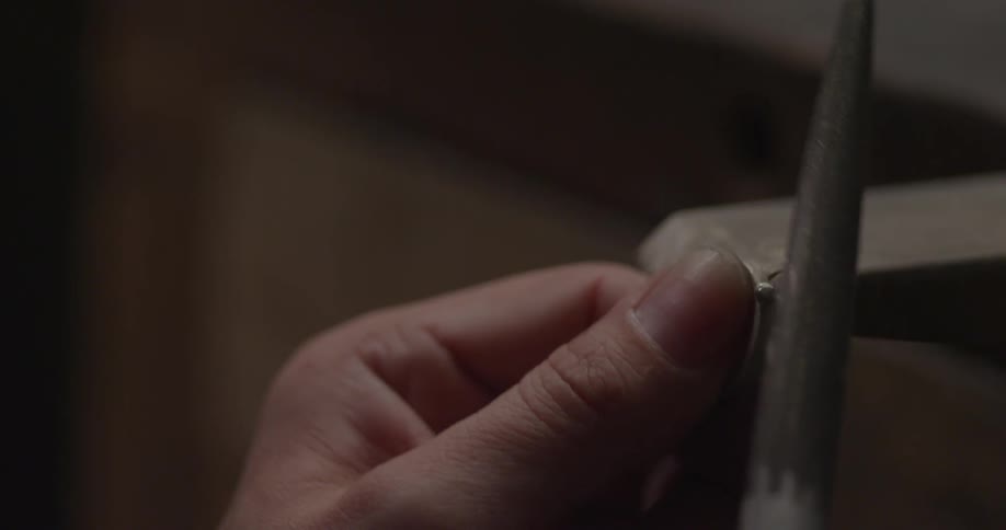 A person using a tool to file a ring