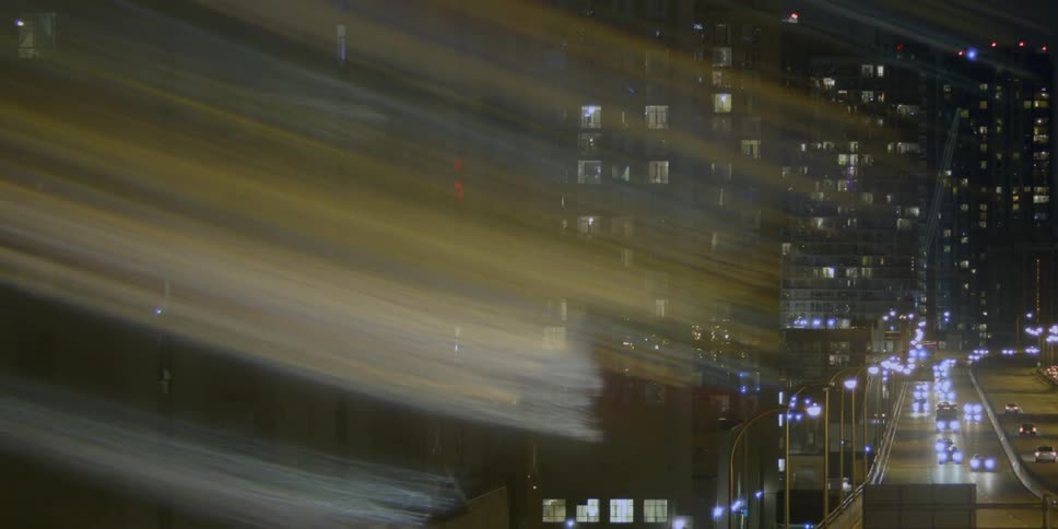 Cars driving down a city road at night