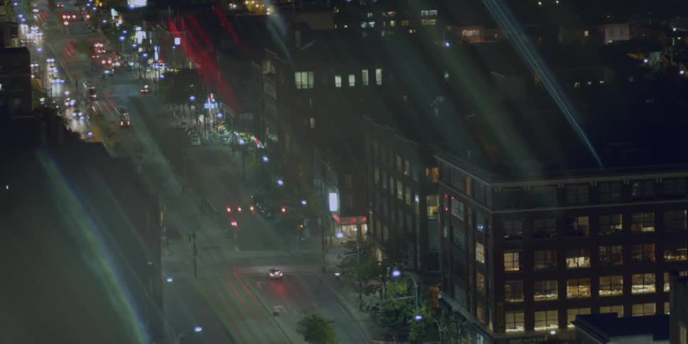 Traffic lights control busy intersections on a city street at night