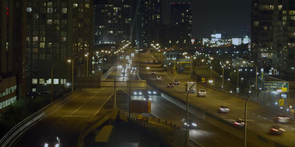 Traffic flowing in both directions on a city highway at night