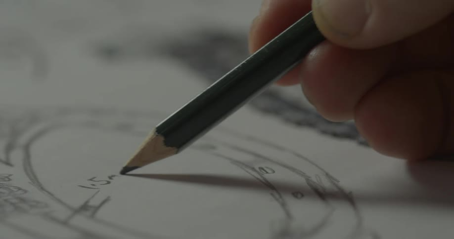A person writes a label on a sketch