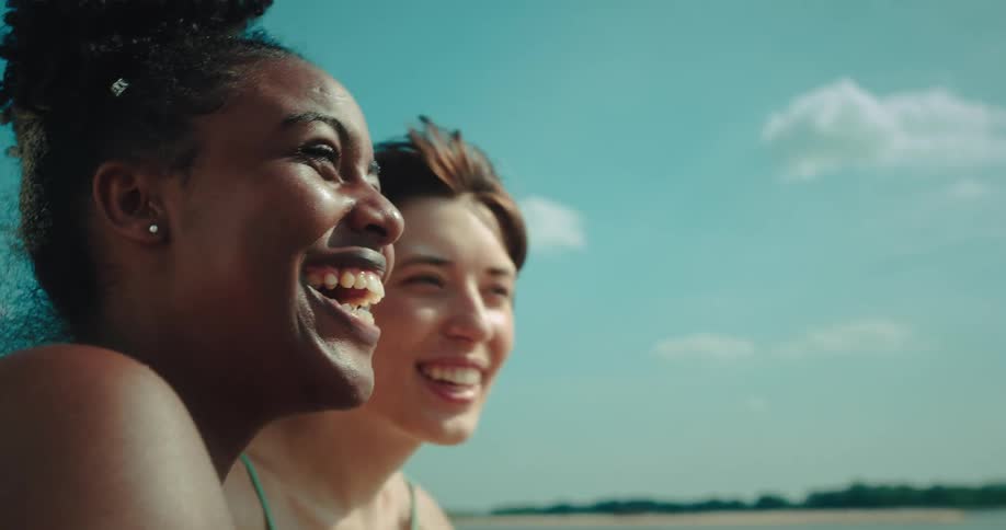 Portrait of two friends happily chatting at the beach