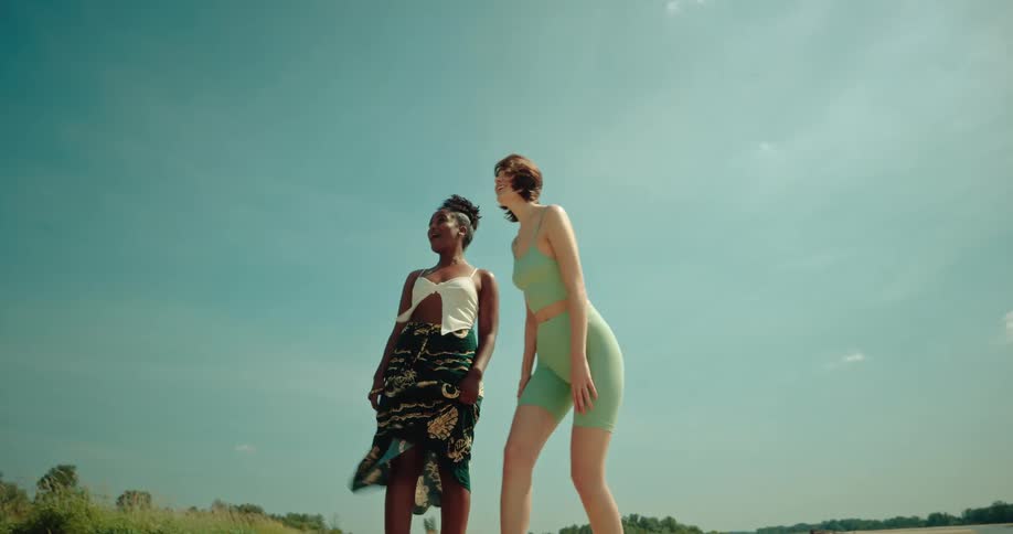 Two woman talking and pointing at a region next to the sea