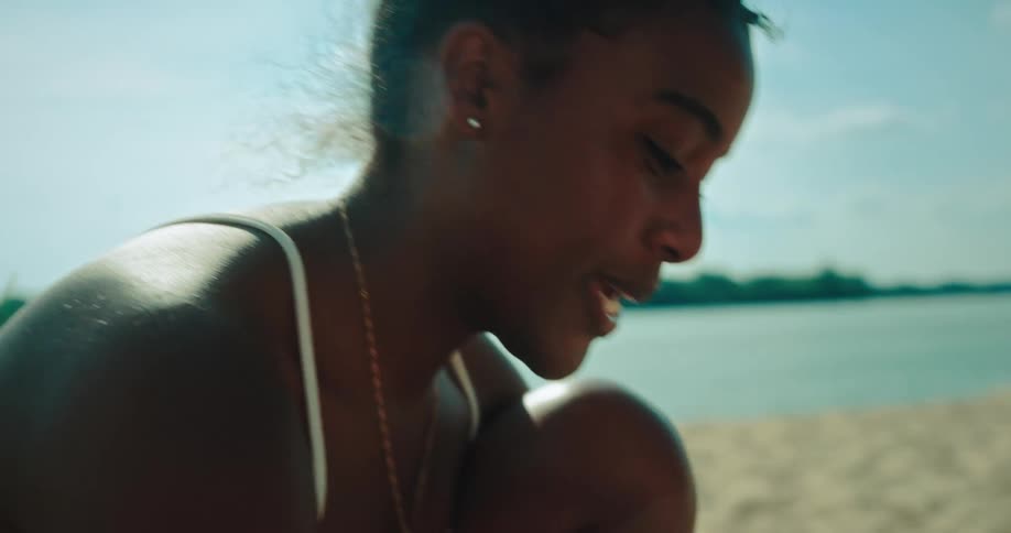 Woman in a white bikini plays card on the beach