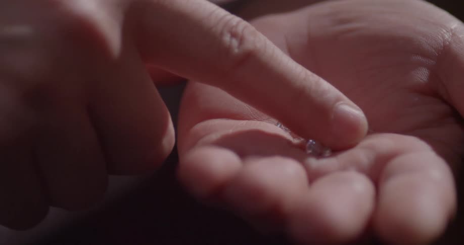 Someone stirs the diamonds in the palm of a hand