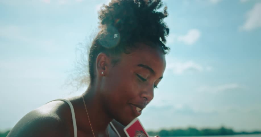 Portrait of a woman at the beach playing a card game
