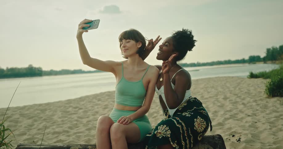 A clip of two ladies taking a selfie at the beach