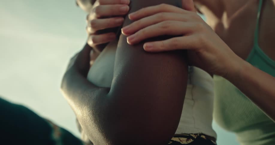 Woman affectionately hugging another woman from behind