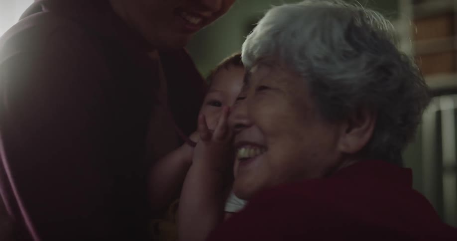 A family greet their grandmother at home