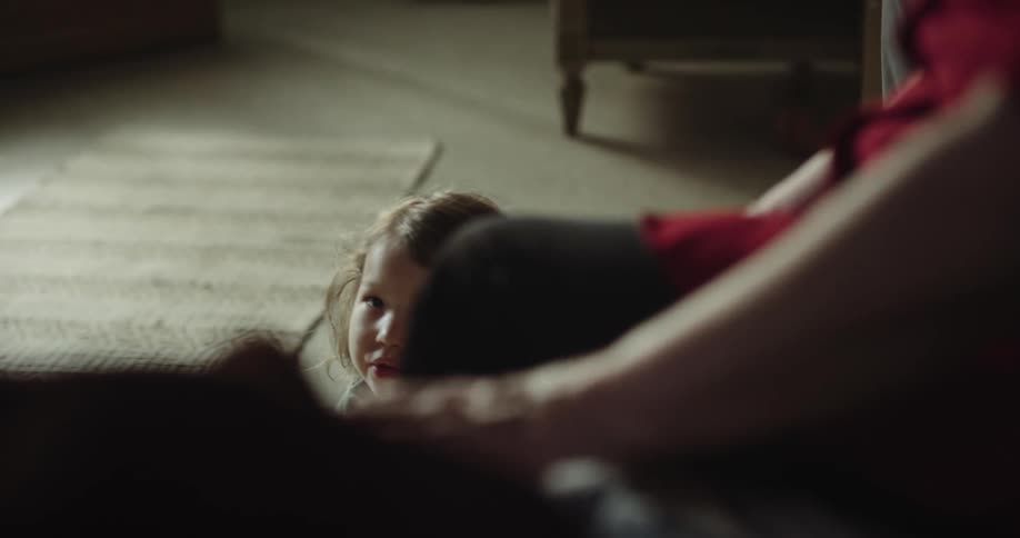 Small child walking towards a person and falling to the ground
